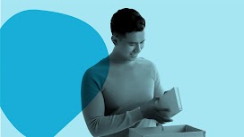 一位亞洲男性正在打開收到的包裹。