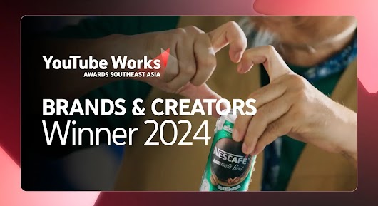 A close-up of two people's hands, with one person holding a green Nescafe canned coffee and the other person forming a half-heart shape with their fingers. Large white text is overlaid on the image, reading: "BRANDS & CREATORS Winner 2024," positioned next to the YouTube Works Awards Southeast Asia logo.