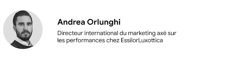 Portrait d'Andrea Orlunghi, directeur international du marketing axé sur les performances chez EssilorLuxottica. Il a la peau claire, des cheveux noirs courts, ainsi qu'une barbe et une moustache soignées. Il porte une chemise à col blanc sous un pull fon