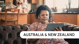 Australia & New Zealand. A woman sitting on a sofa uses a tablet for Search.