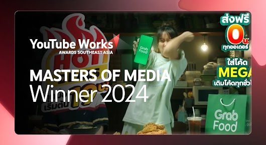 A young woman in a pale green shirt holds a phone displaying the "Grab Food" logo, with her arm raised in a dynamic pose, in what looks like a kitchen setting. A background graphic features red flames and the word "HOT," while large overlaid text reads: "MASTERS OF MEDIA Winner 2024" next to the YouTube Works Awards Southeast Asia logo. 