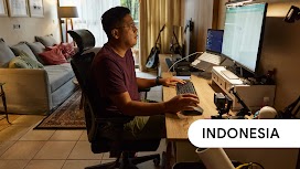 Indonesia. A man using Google Search on his computer at his study desk at home.
