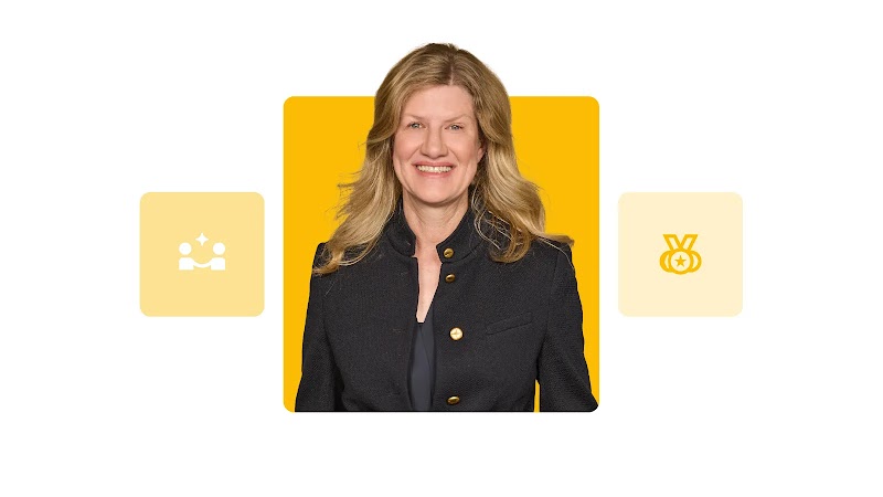 Die Vorstandsdirektorin Julia Vander Ploeg ist lächelnd abgebildet, zwischen Icons, die Kommunikation und Erfolg darstellen. Vander Ploeg hat helles, schulterlanges Haar, helle Augen sowie helle Haut und trägt eine schwarze Jacke.