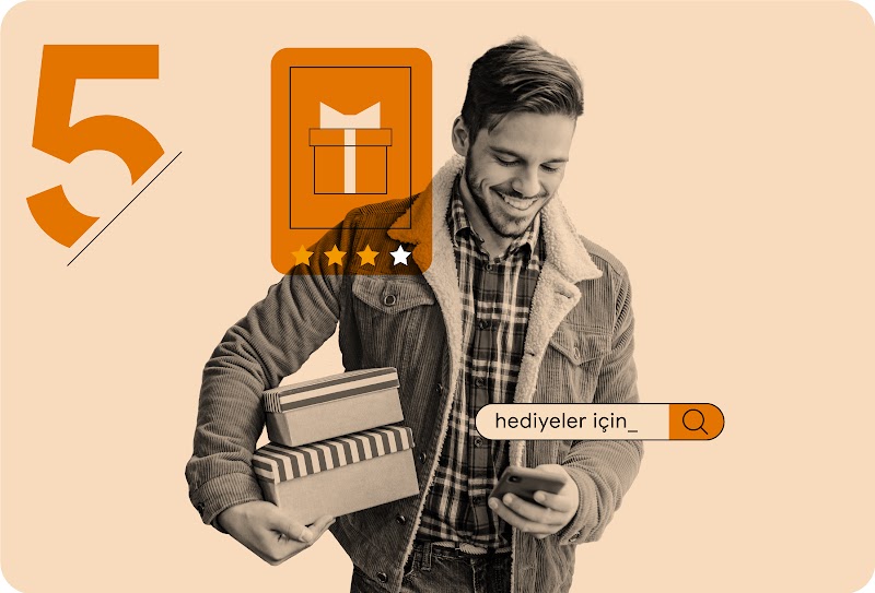 Oduncu gömlek ve kadife ceket giyen bir kişi, bir elinde hediye alışverişi için cep telefonuna bakarken diğer elinde iki hediye paketi tutuyor.