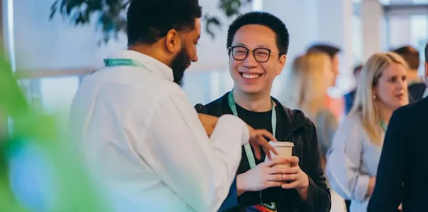 Two professionals conversing and smiling at an event, with the Google for Startups logo overlay.