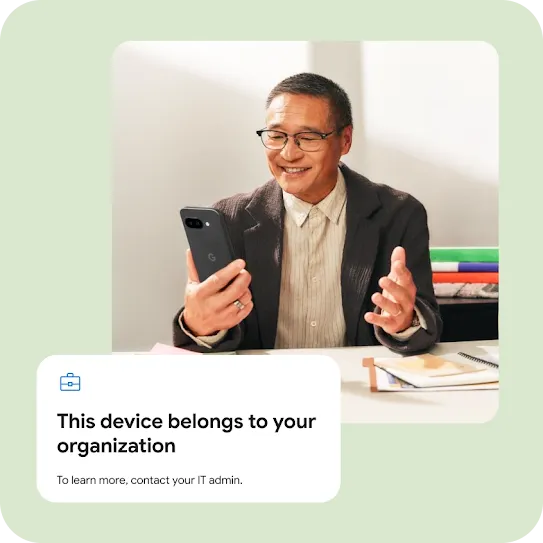 A smiling man holding a dark smartphone, featuring an overlaid management notification that reads, "This device belongs to your organization."