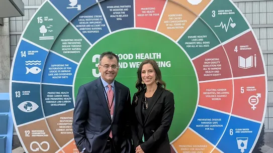 Google’s Karan Bhatia and Melike Yetken Krilla standing in front of a large, circular display of the 17 United Nations Sustainable Development Goals (SDGs) during the United Nations General Assembly.