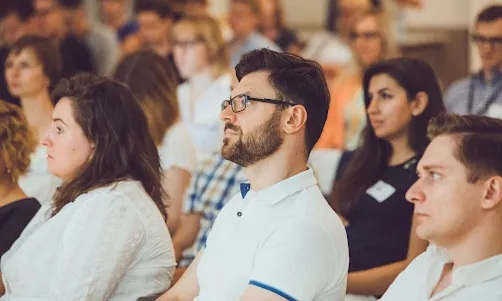 A man in conference listening to speaker.