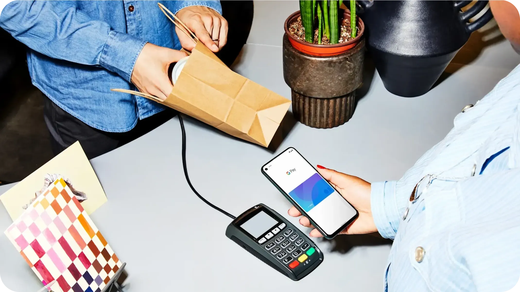 Person holding a phone to a contactless payment system