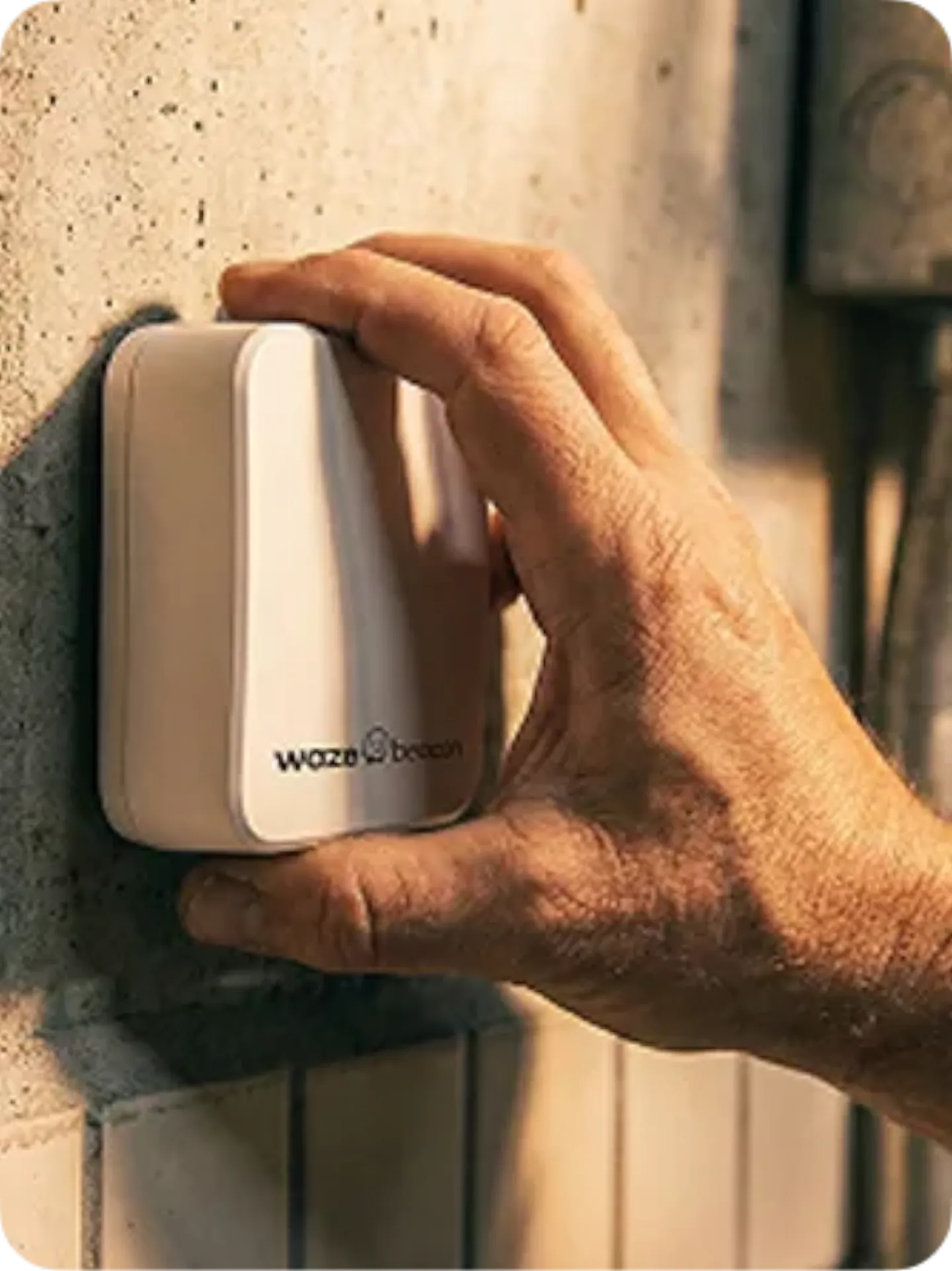 Hand installing a Waze Beacon Bluetooth hardware device on a tunnel wall for underground navigation
