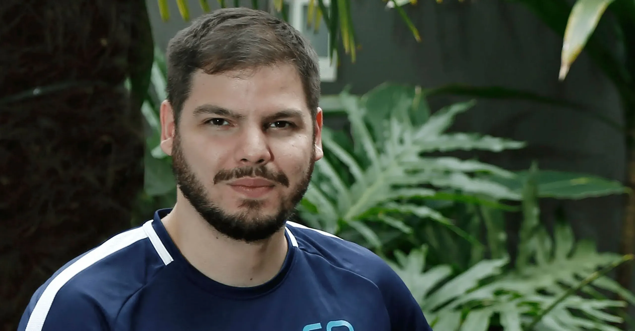 Homem sentado posando para foto.