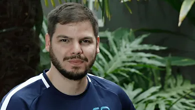 Homem sentado posando para foto.