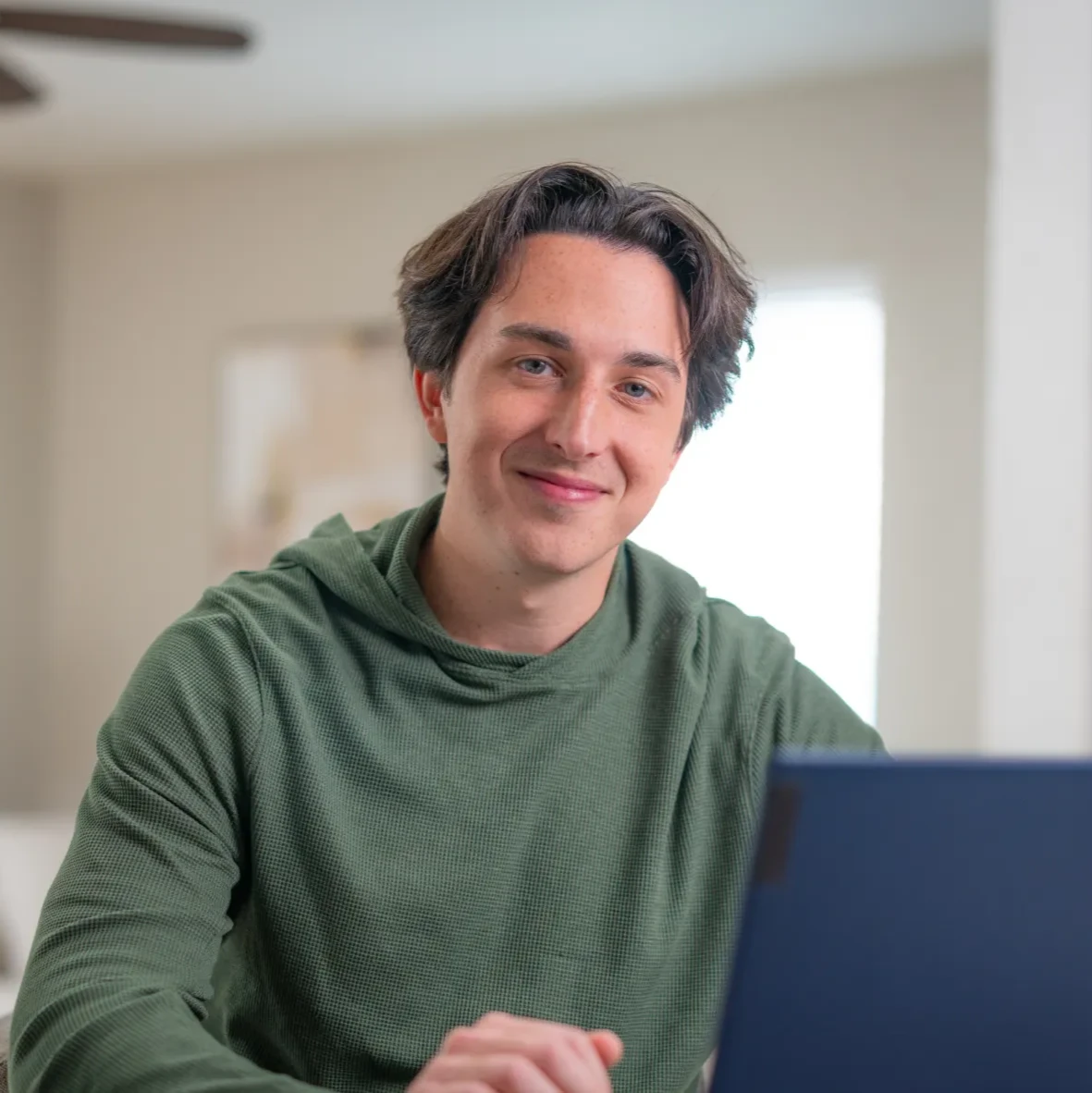A man looks at a computer smiling