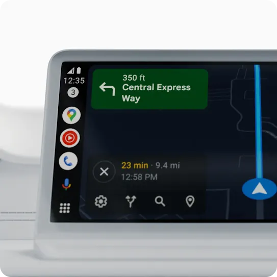 A black phone has “Android Auto” on its screen. Behind it is Google Maps on a car display.