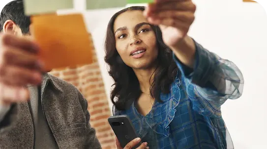 Woman holding Android phone in discussion with man holding an Android tablet