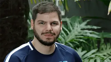 Homem sentado posando para foto.