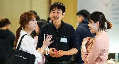 Two women and a men discussing something and laughing.