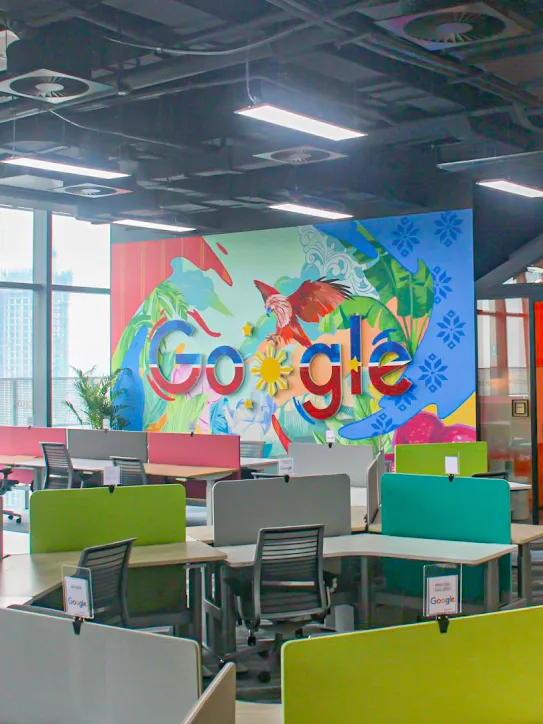 Een werkruimte met het Google-logo en allerlei bureaus.
