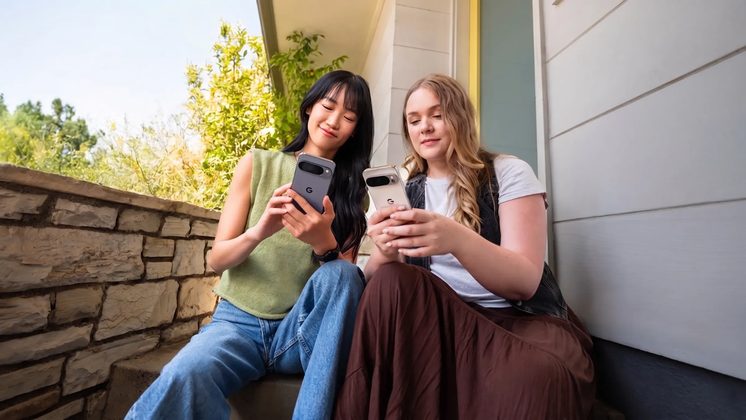 Women sitting at a staircase using their Pixel 10 devices.
