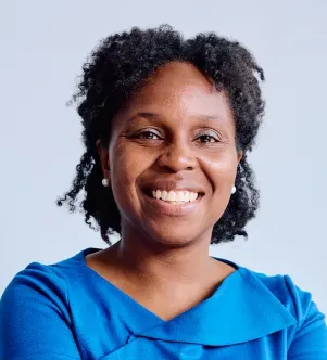 Headshot of Tina Williams-Koroma, founder of CyDeploy, smiling and wearing a vibrant blue blouse against a light gray studio background.