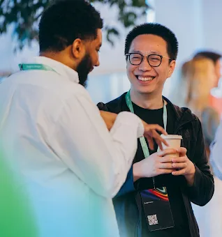 Two professionals conversing and smiling at an event, with the Google for Startups logo overlay.