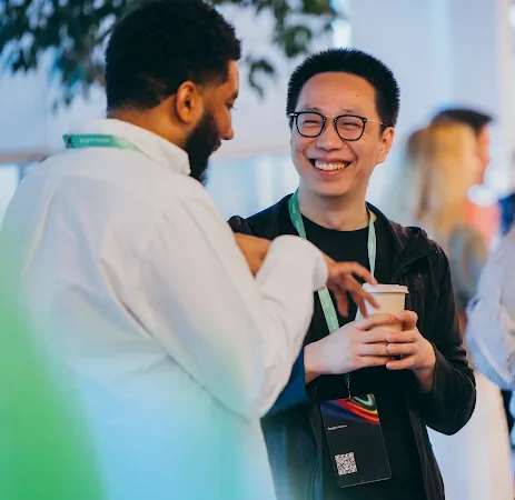 Two professionals conversing and smiling at an event, with the Google for Startups logo overlay.