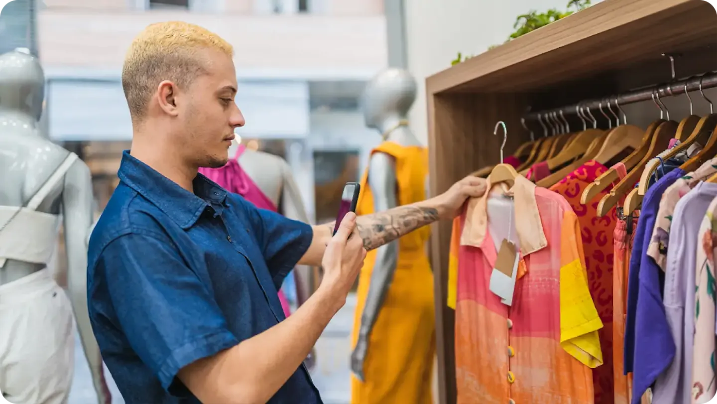 Customer taking a picture of shirt in a retail store on their smartphone.