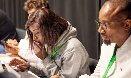 A man and woman watching on their laptops.