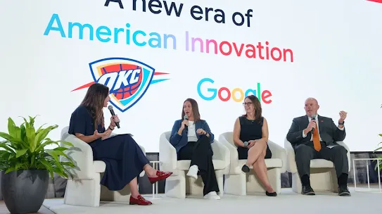 A panel discussion taking place on a stage with four people seated in white armchairs. A screen behind them displays the text "A new era of American Innovation" above the OKC Thunder logo and the Google logo.