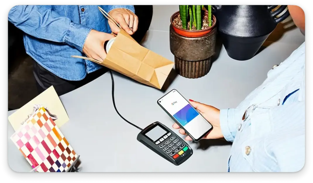 Person holding a phone to a contactless payment system