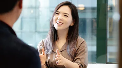 Founder Hanna Kim gestures to a colleague across a table.
