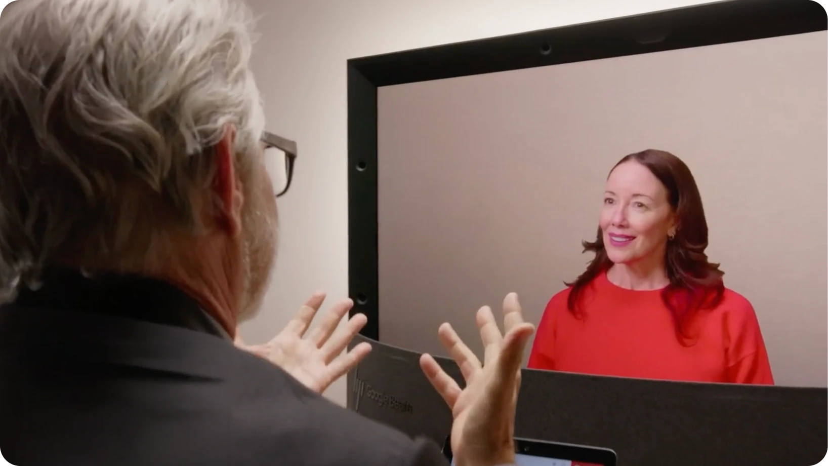 A person talks expressively to a team member during a Google Beam video meeting.