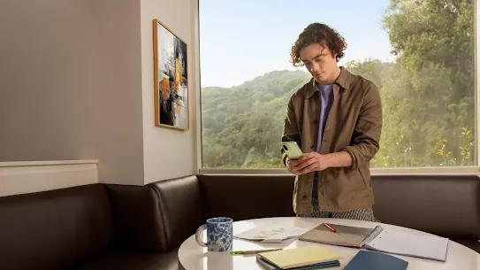 A man using his Android smartphone indoors.