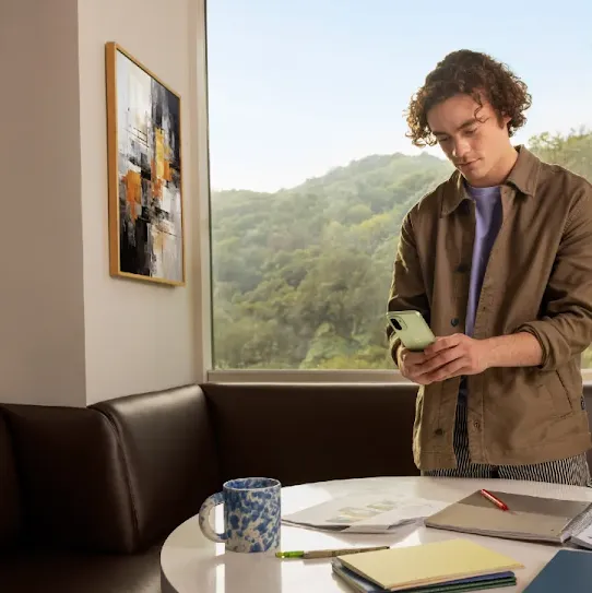 A man using his Android smartphone indoors.