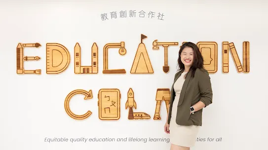 Rachel Huang from Junyi Academy stands in front of organization's sign in Taipei Taiwan