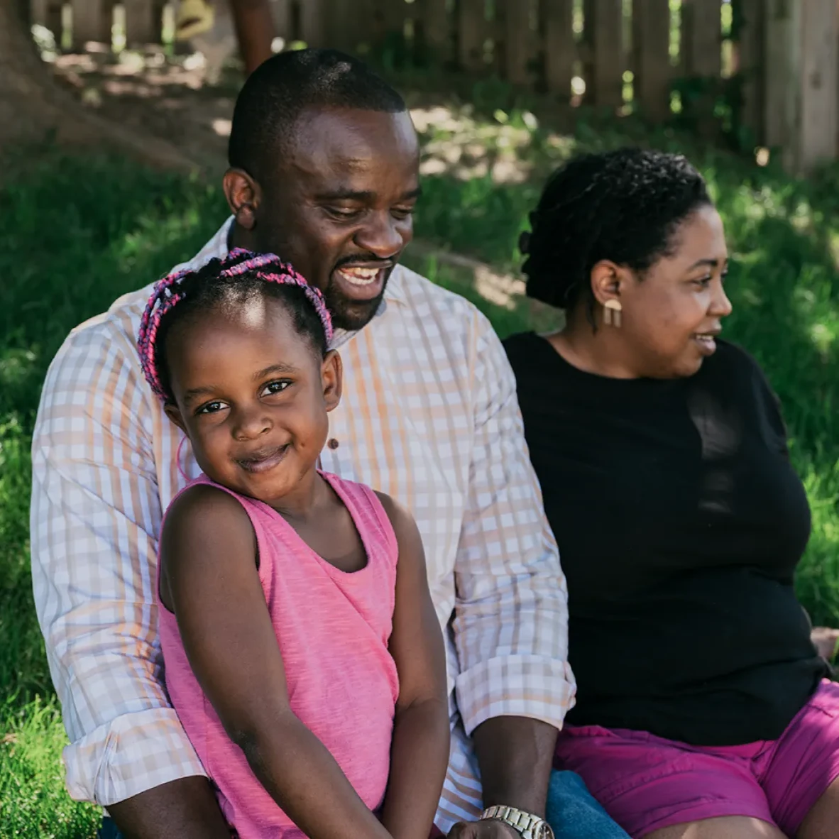 A site lead at one of our Nebraska data centers, rests in his backyard with his wife nearby and his daughter in his lap.