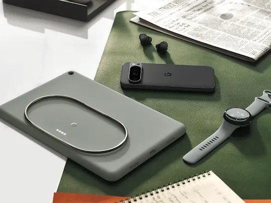 Android phone, tablet, watch and earbuds placed together on a table.