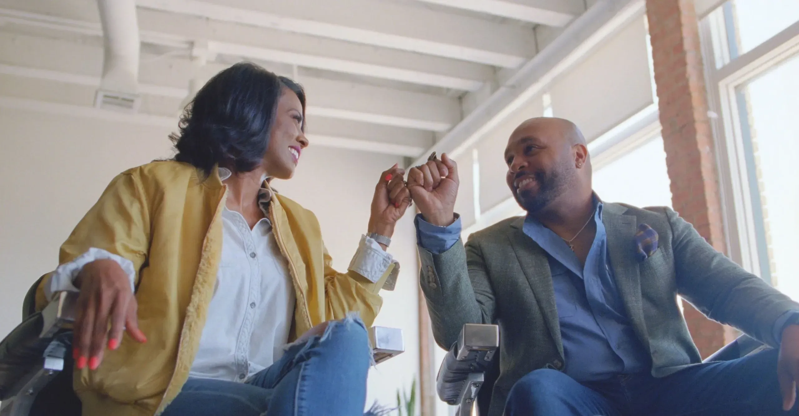woman and man fist bump and smile at one another