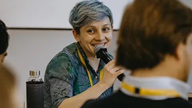 Tina Bychkova, Head of Digital Marketing, is speaking at a conference with colleagues.