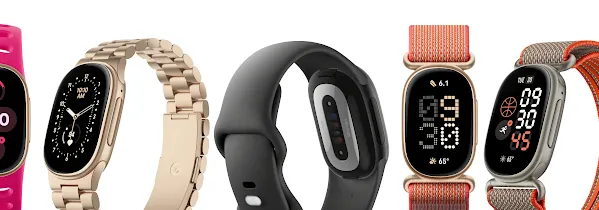 A line of Fitbits with different color bands, including pink, gold, black, and orange.