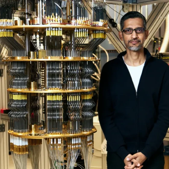 A picture of Sundar Pichai standing next to a quantum computer