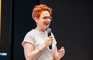 A female host, with a mic in hand, is delivering an excellent event.
