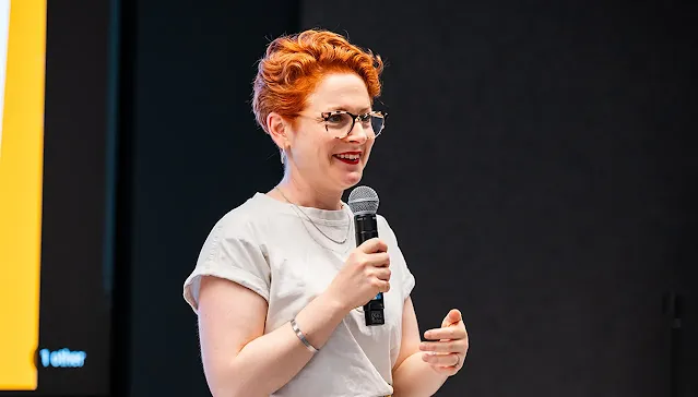 A female host, with a mic in hand, is delivering an excellent event.