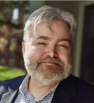 Close-up portrait of Jason Neiffer, Executive Director of Montana Digital Academy, smiling with a short gray beard and glasses, featured in a case study about AI in rural education.