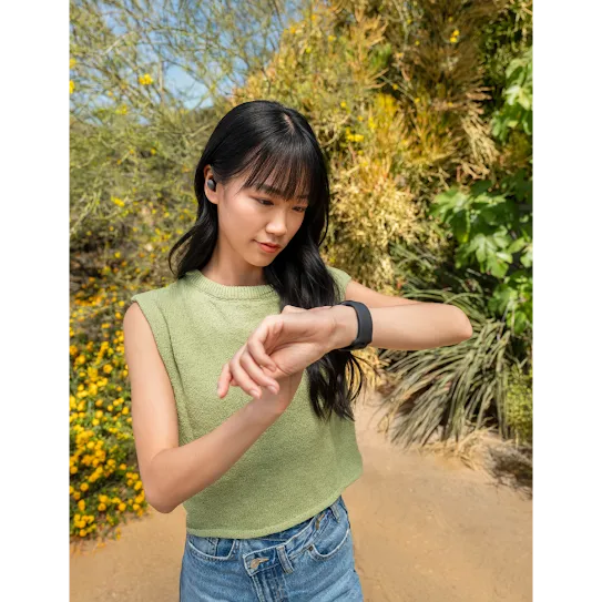 Une personne marche et regarde sa montre intelligente Wear&nbsp;OS.
