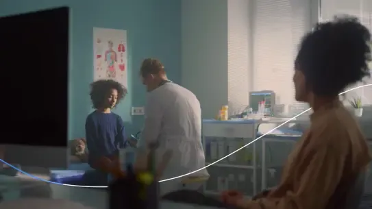 Doctor treating girl with parent looking on
