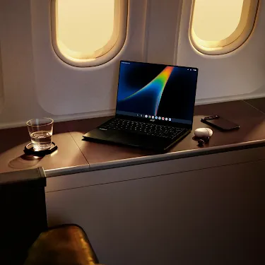 Googlebook open on an airplane tray table.
