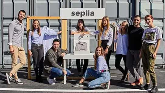 The team of Sepiia pose in front of their sign outside.