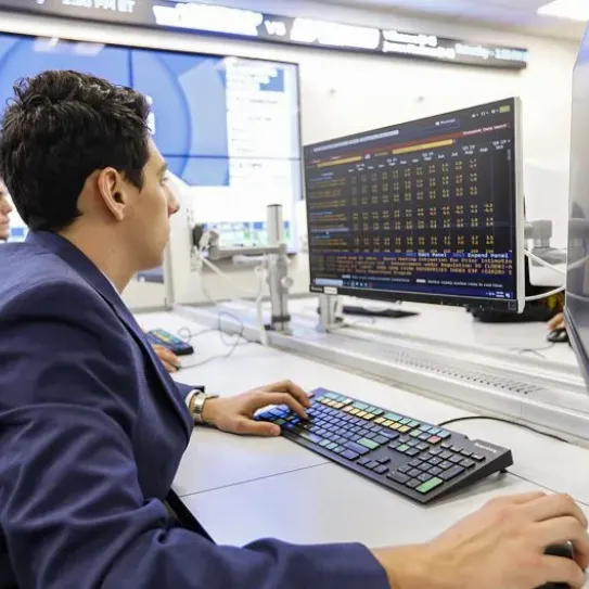 man on desktop computer sitting next other man on computer