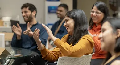 A group of people clapping while laughing
